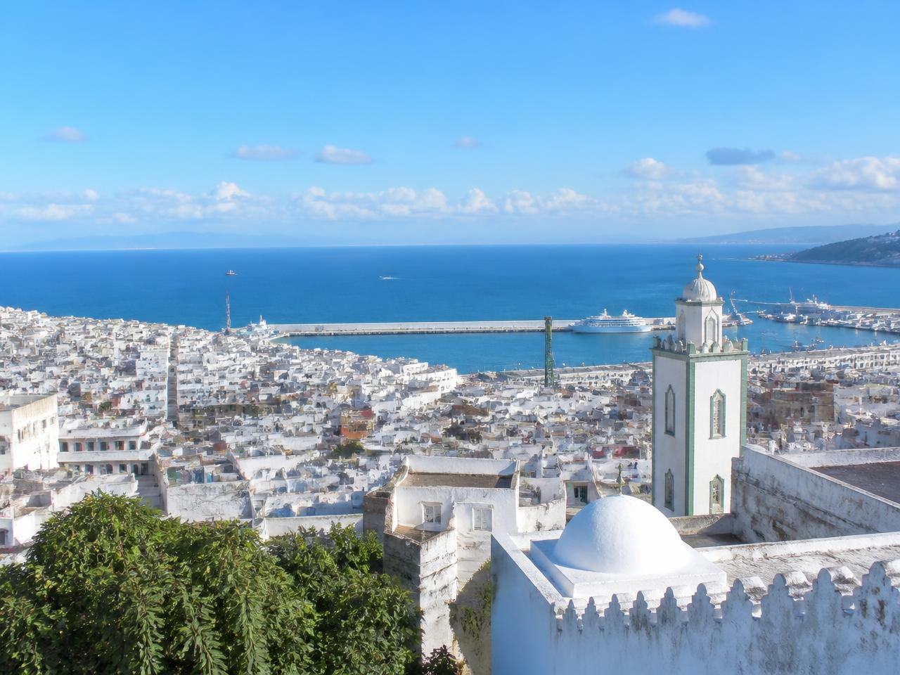 Vue panoramique de Tanger en journée : la médina blanche, le minaret et le port sur la baie